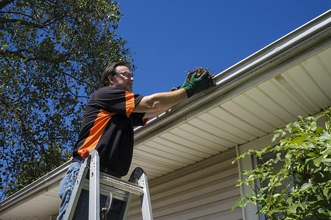 a technician fixing a damaged gutter system in Accokeek, MD